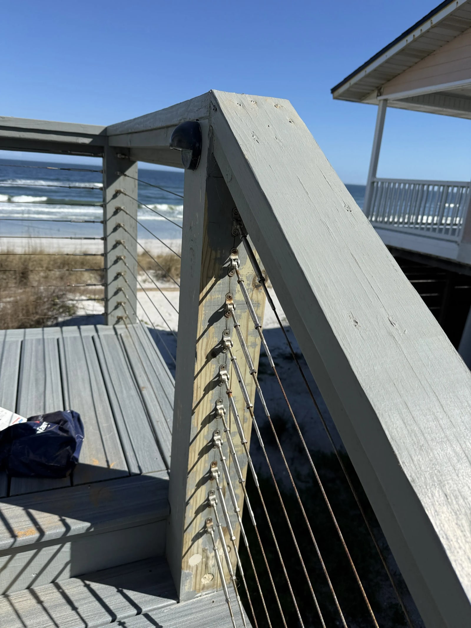 Weathered wood deck and railing prepared for refinishing at a Vilano Beach rental property